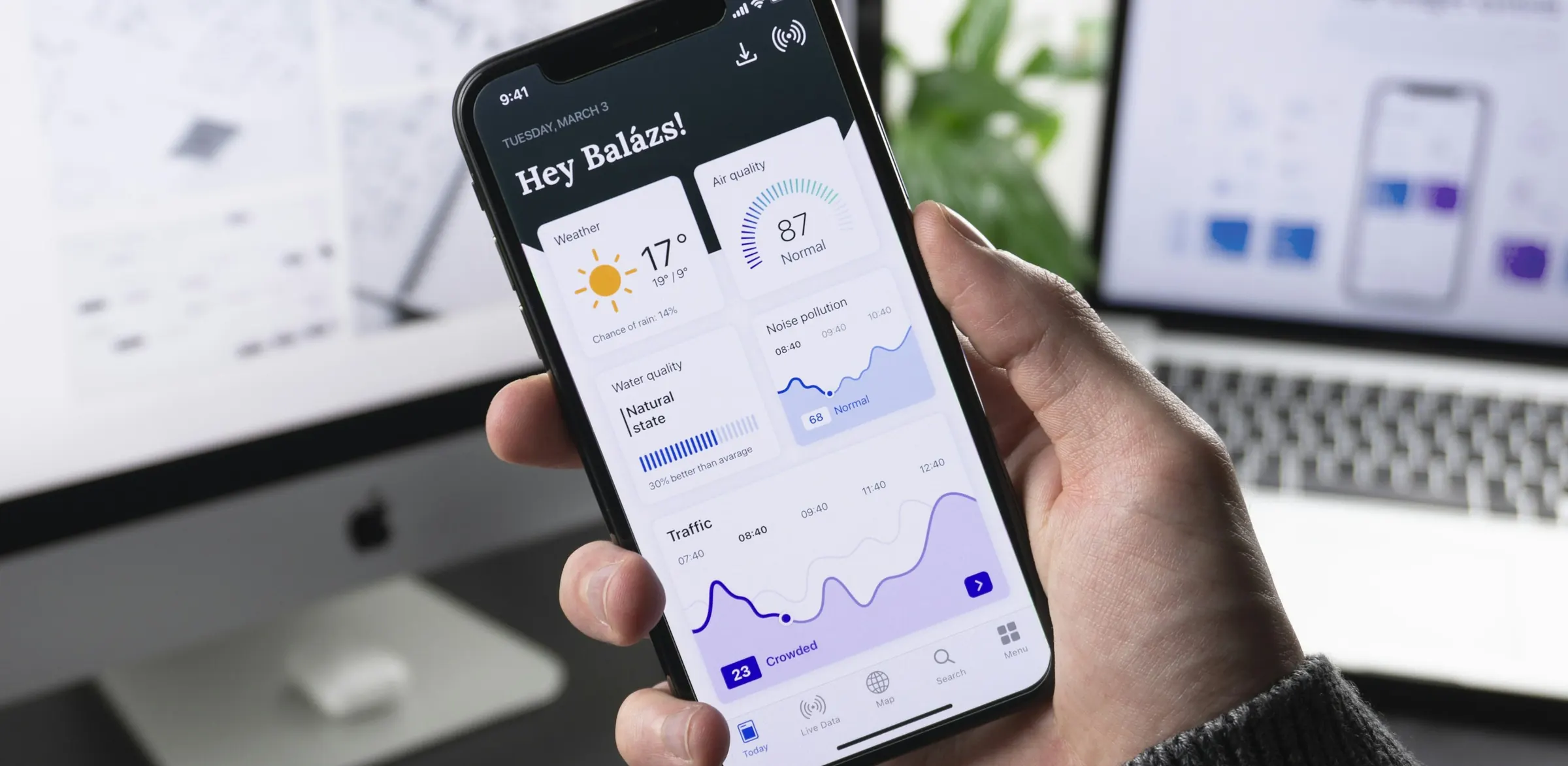 Phone showing a mobile app next to a laptop